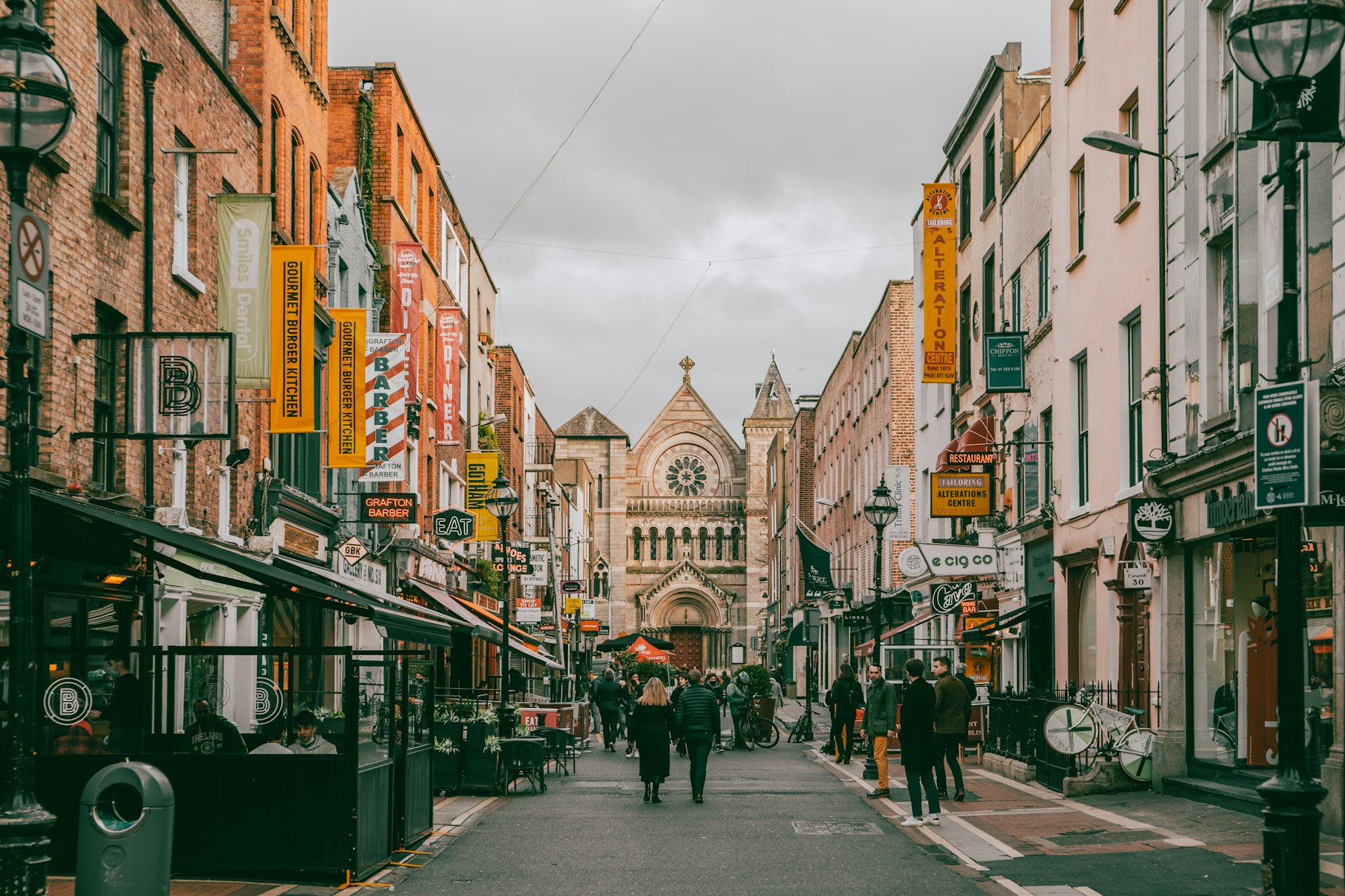 Shoppers on a Dublin street lined with red-brick buildings