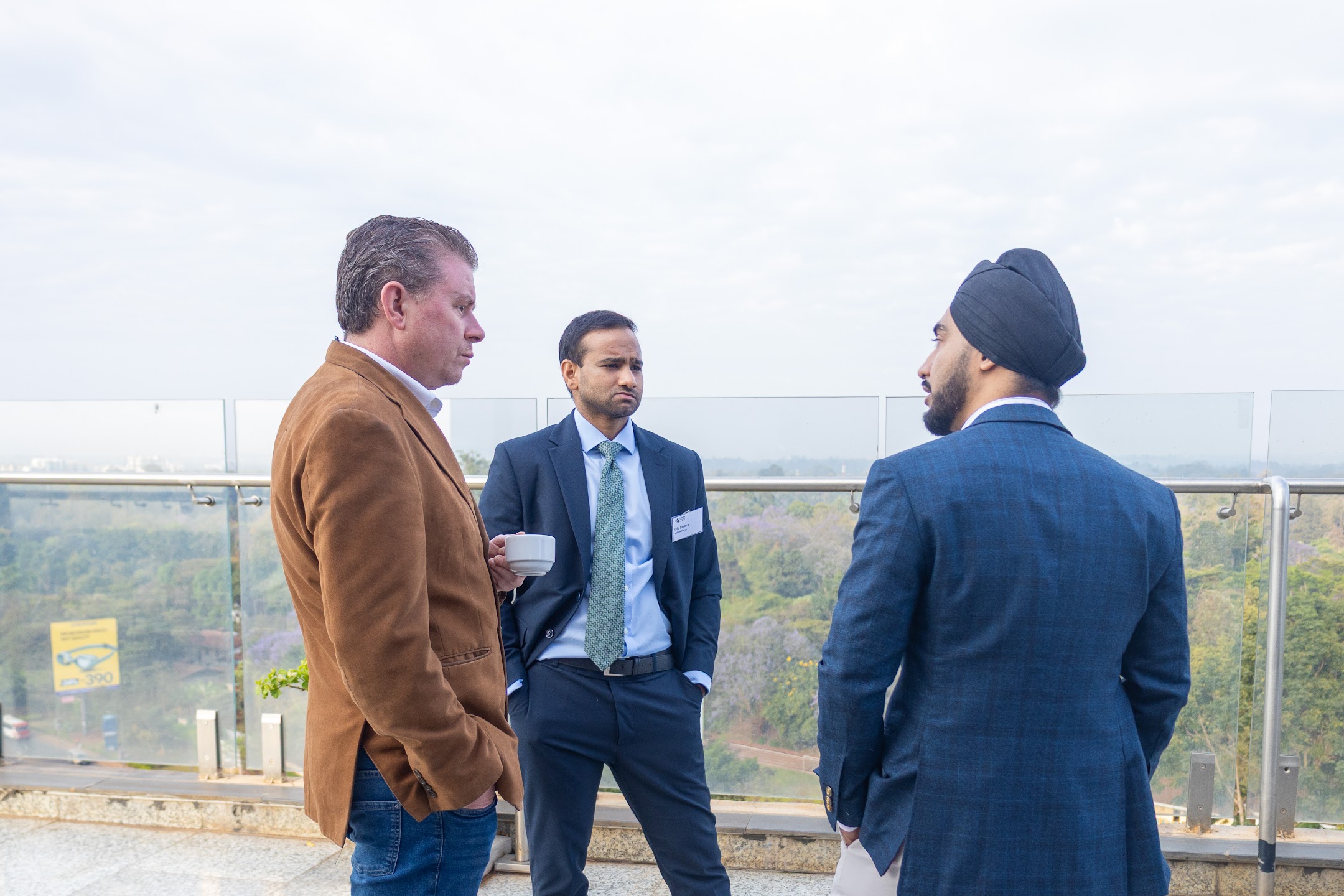 Three business guests conversing on a rooftop